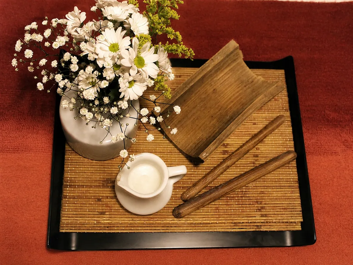 Bandeja com flores e acessórios de massagem no Ikigai Spa