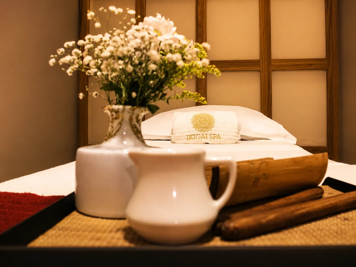 Bandeja de massagem com flores e toalhas no Ikigai Spa